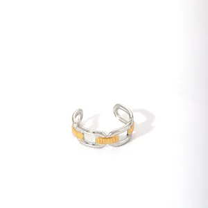Macro detail of two-tone chain link design open ring with polished gold and silver finish