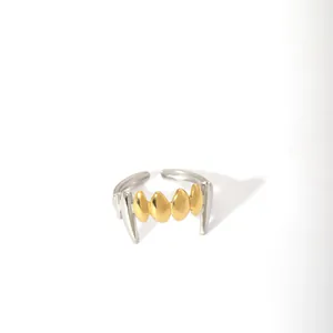 Detailed view of dual-tone gothic vampire fangs open ring in gold and silver finish