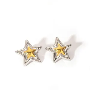 Detalle de pendientes de estrella bicolor oro y plata con diseño de capas metálicas