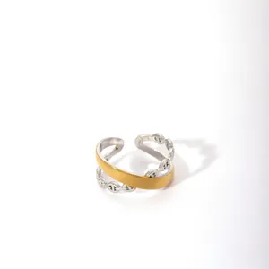 Detail of two-tone gold and silver cross ring featuring an anchor link chain design