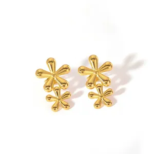 Detailaufnahme der doppelten goldenen Blumenohrringe mit hochglanzpoliertem Finish