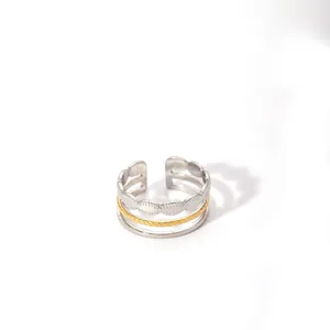 Detail showing the three-layer mixed metal textures and adjustable open band on the ring