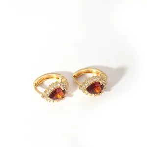 Close-up of gold stainless steel hoop earrings with orange pear-cut stones and zircon halo