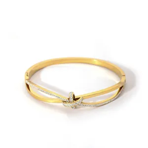 Detailed view of a gold double-layer bangle with a twist knot and white zircon inlay