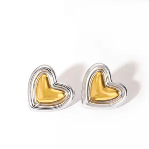 Primer plano de pendientes de corazón bicolor con borde plateado y centro dorado