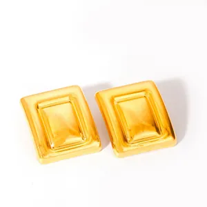Vista macro de pendientes rectangulares dorados con un acabado de metal pulido fino