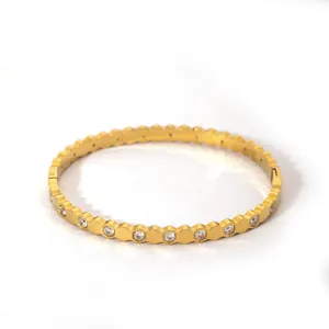 Detail of gold wave bangle featuring scalloped edges and sparkling inset zircons