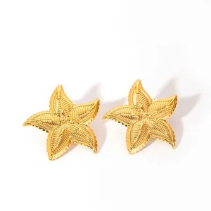 Vista macro de pendientes de estrella de mar dorados con textura radial en la superficie metal