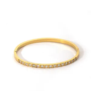 Close-up of gold-plated copper bangle with inlaid circular cubic zirconia crystals