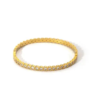 Detailed close-up of golden honeycomb bangle with sparkling cubic zirconia settings