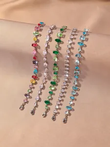 Detailed view of colorful zircon bracelets with various gemstone cuts on silk background