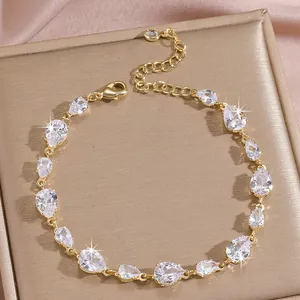 Detailed macro view of gold-plated bracelet with teardrop zircon stones and lobster clasp