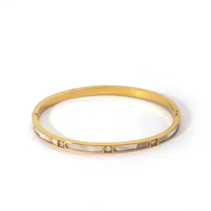 Macro view of gold copper bracelet with white shell inlays and cubic zirconia accents