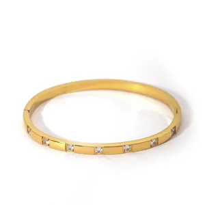 Detail view of gold-plated hinged bangle featuring inlaid round cubic zirconia stones