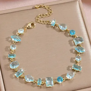 Detail of adjustable gold bracelet with various blue cubic zirconia stone shapes