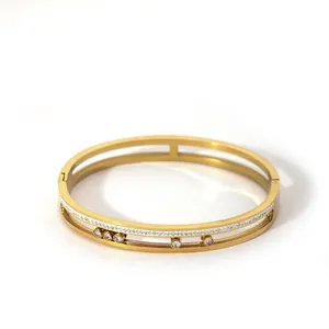 Detailed close-up of gold double-layered bangle featuring five sliding round zircons
