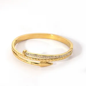 Detail of gold nail bracelet with cubic zirconia paving and textured diamond patterns