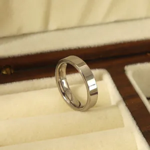 Close-up of a 4mm polished silver stainless steel ring in a luxury wood jewelry box