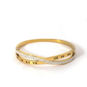 Macro detail of 18K gold-plated bangle with Roman numeral engravings and pavé crystals
