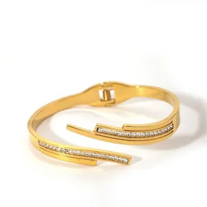 Detailed close-up of a gold-plated bangle with rectangular zircon stones and a spring hinge