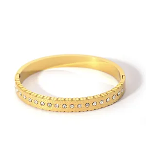 Detail of 18K gold plated stainless steel bangle with engraved hearts and crystals