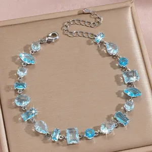 Macro view of silver bracelet featuring irregular blue zircons on champagne metal stand