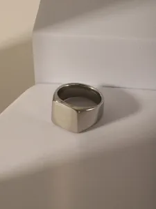 Macro detail of square titanium steel signet ring with brushed finish and polished edges
