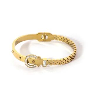Detail of 18K gold plated steel bracelet with pave zircon horseshoe buckle and rivet accents