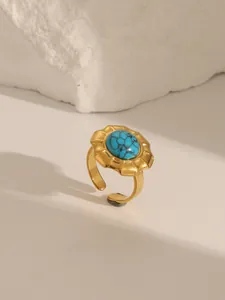 Detailed macro view of a vintage gold-plated ring with a marbled turquoise stone inlay