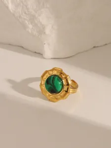 Detail of vintage gold ring with a green malachite stone and textured wavy edges