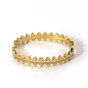 Gold-plated minimalist bangle with pyramid studs and clear cubic zirconia inlays