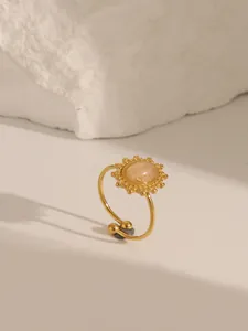 Détail macro d'une bague vintage dorée en acier inoxydable avec pierre champagne et motif
