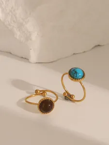 Detail of vintage bohemian open rings with round turquoise and tiger eye stone inlay