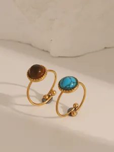 Detail of adjustable gold rings with natural brown tiger eye and blue turquoise stones