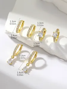 Detail showing three gold earring styles with cubic zirconia and dimensions on stone background