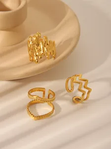 Detailed shot of three gold stainless steel rings with unique textures and adjustable bands