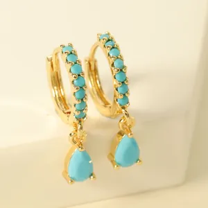 Detailed view of gold-plated hoop earrings with turquoise beads and teardrop pendants