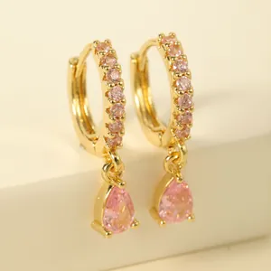 Detailed macro view of gold-plated earrings with drop pear-cut pink crystal accents