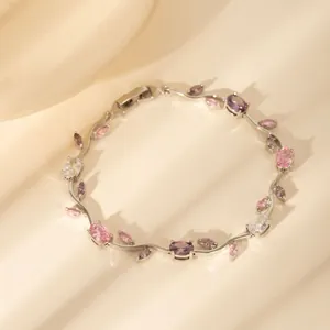Detail eines silbernen Blattarmbands mit rosa und lila Zirkonia im natürlichen Schatten