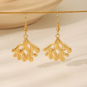 Unregelmäßige goldene Korallen-Ohrhänger mit Textur in minimalistischer Präsentation