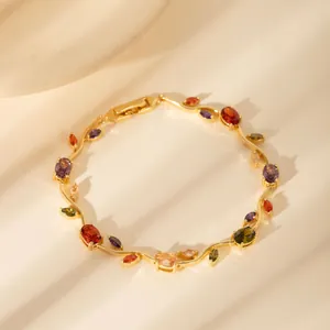 Detail eines vergoldeten Blattarmbands mit bunten Zirkonsteinen auf gewellten Gliedern