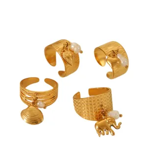 Set of four gold plated open rings with heart, elephant charms and baroque pearls