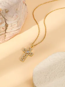 Detailed close-up of a gold-plated stainless steel cross necklace featuring rhinestones.