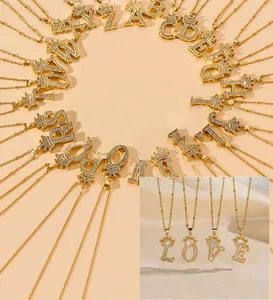 Macro view of gold initial necklaces with crown charms and sparkling rhinestones