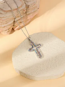 Close-up detail of the elegant cross pendant necklace with sparkling colorful stones.