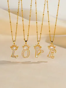 Detailed view of gold plated LOVE letter necklaces with crown pendants and sparkling zircons