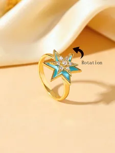 Detailed view of rotating gold plated ring with blue enamel and star zircon inlay