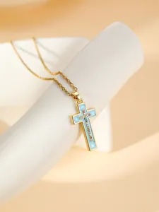 Gold plated stainless steel cross necklace detail shot with blue enamel and sparkling rhinestones.