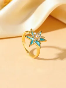 Detailed macro shot of a gold-plated hexagram ring featuring blue enamel and cubic zirconia