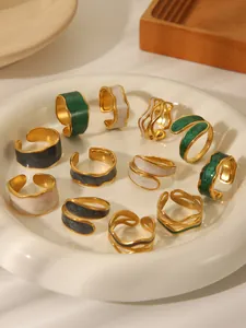 Macro shot of retro gold-plated enamel rings with irregular edges on a white ceramic tray